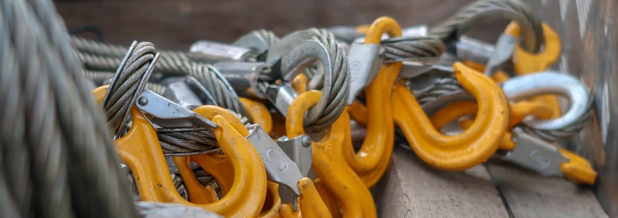 Viele Kranhaken sind befestigt an Stahlseilen