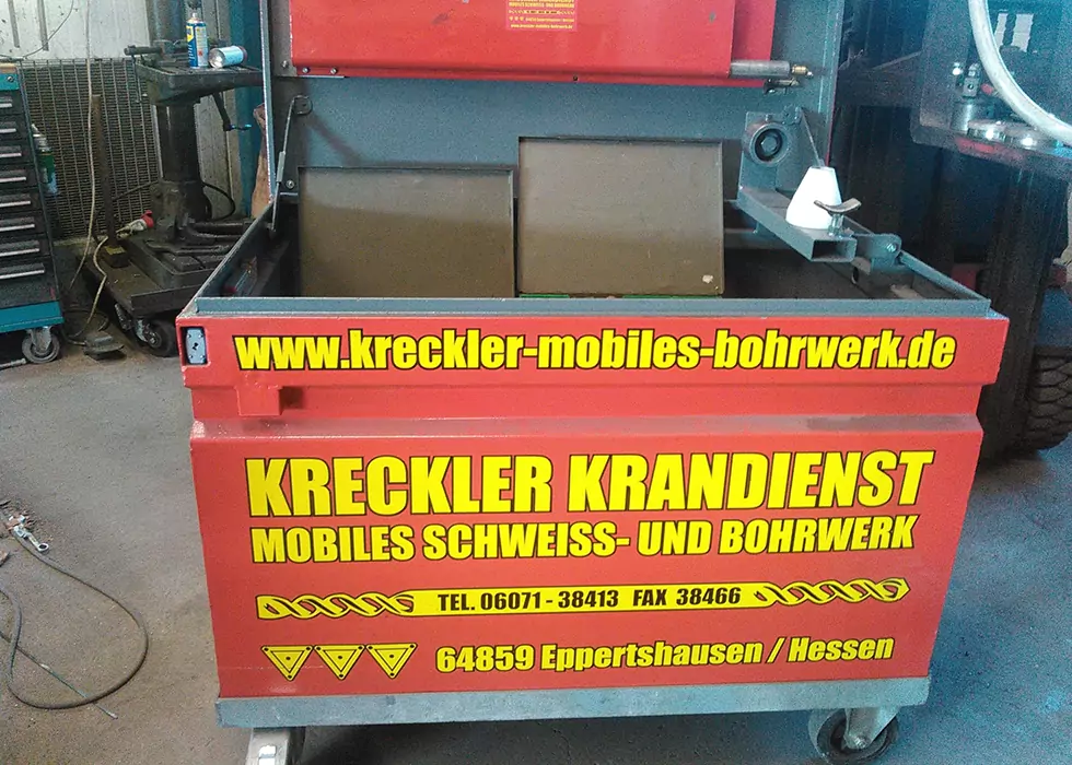 Rote große Transportkiste für Werkzeug mit großer Aufschrift Kreckler Krandienst in einer Werkstatt