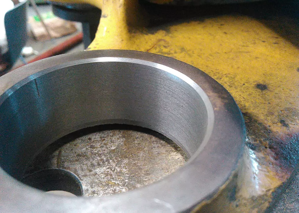 Metallstück mit großer Bohrung liegt auf der Werkbank